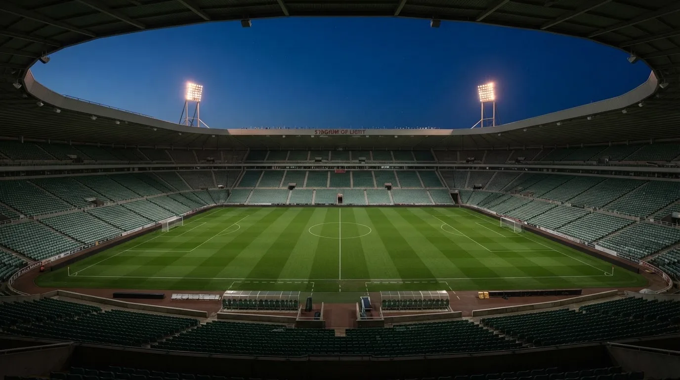 Een leeg voetbalstadion met lichtmasten bij schemering
